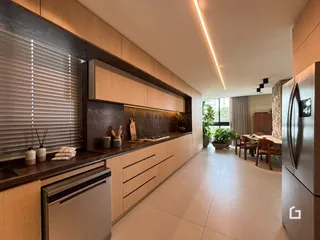 Vista de uma cozinha moderna com armários de madeira e piso claro.