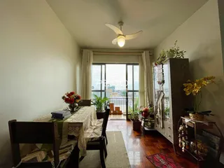 Ambiente interno de uma sala com piso de madeira e grandes janelas.