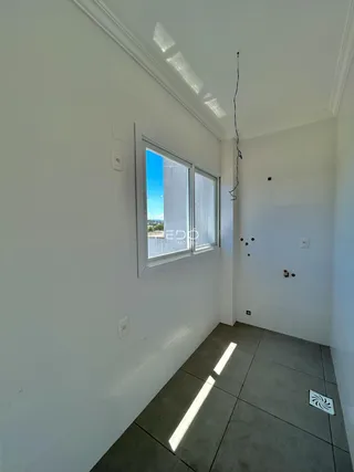 Vista de um corredor interno com janela de vista para o exterior.