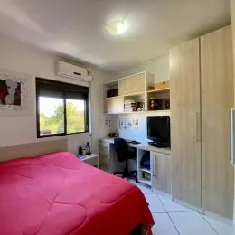 Quarto com cama e janela visível na lateral da parede.