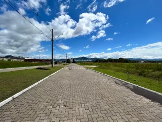 Vista externa de uma estrada pavimentada em uma área gramada.