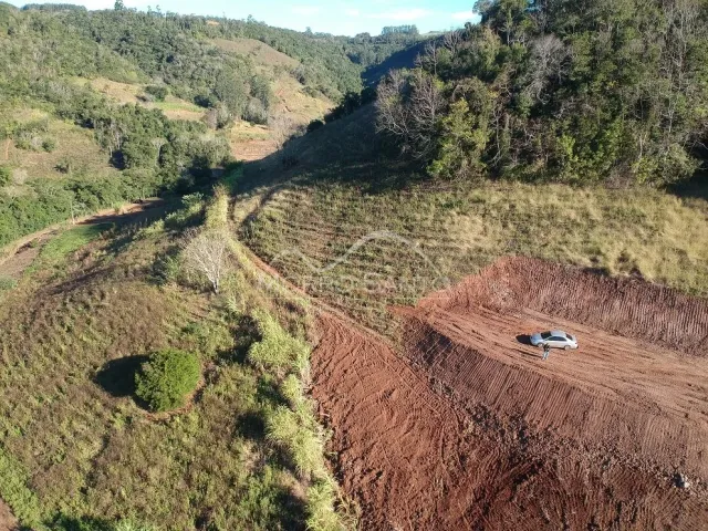 Vista de uma colina com vegetação seca e terra avermelhada no interior de Lajeado.