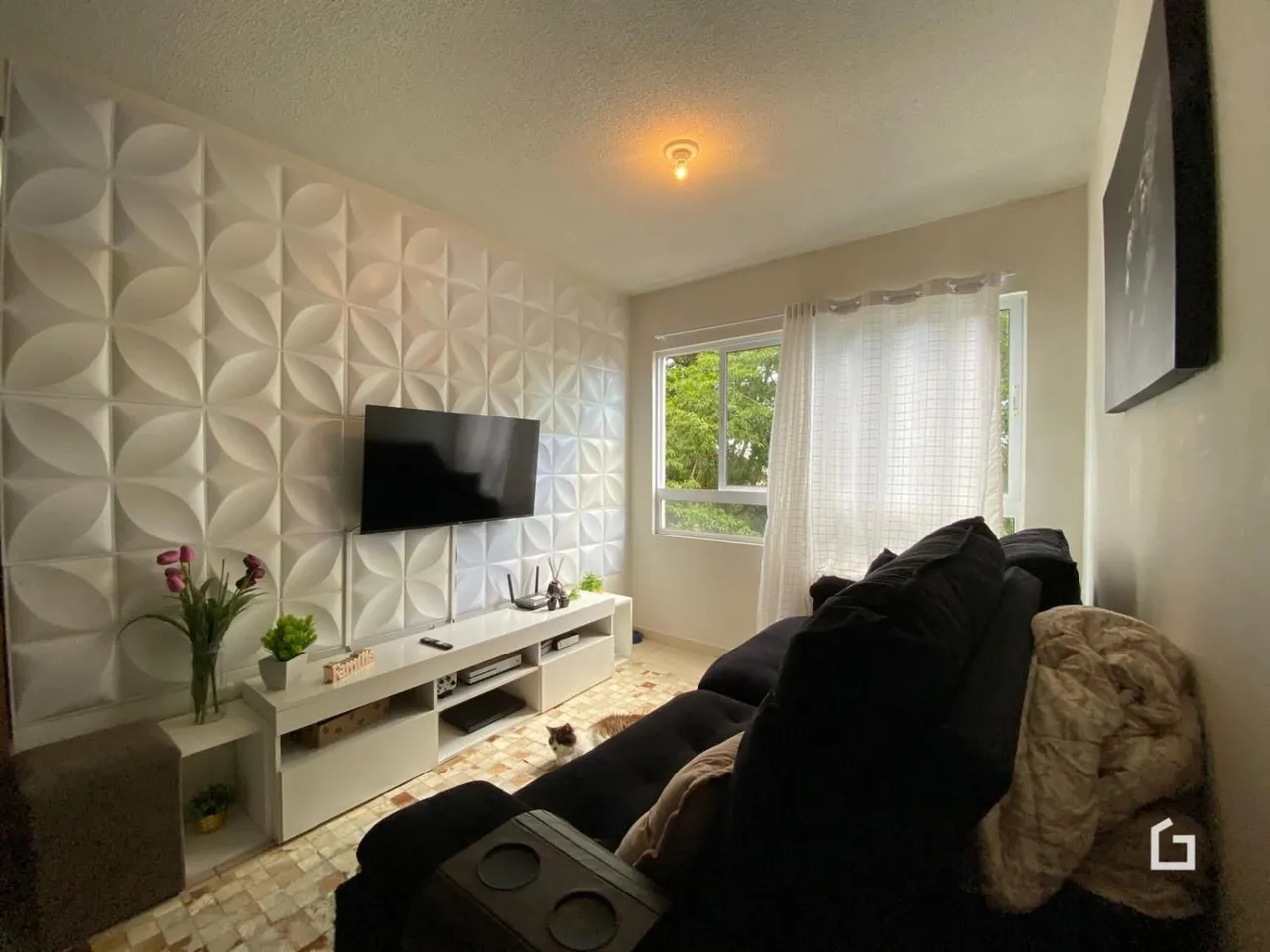 Sala de estar com parede texturizada e televisão.