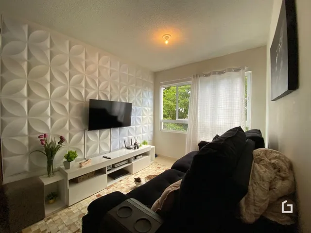 Sala de estar com parede texturizada e televisão.