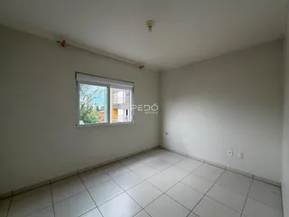 Ambiente interno de uma sala com piso de cerâmica e janela.