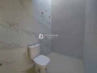 Foto de um banheiro com paredes em mármore branco.