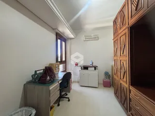 Quarto com painel de madeira e janela em um imóvel no Brasil.
