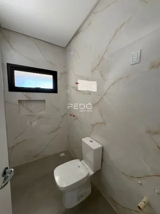 Foto do interior de um banheiro com azulejos brancos.