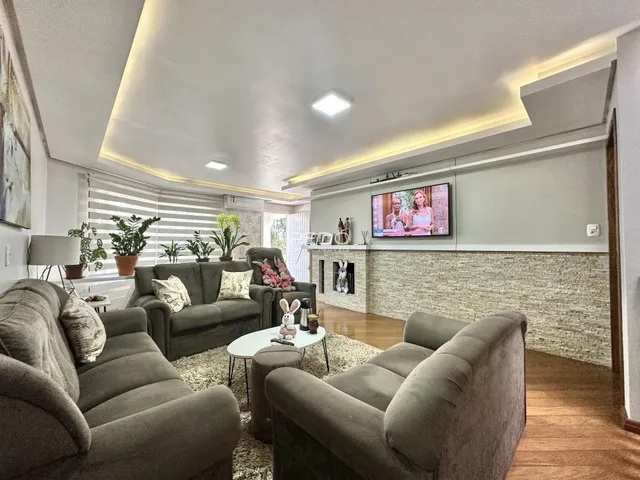 Sala de estar moderna com sofás e piso de madeira.