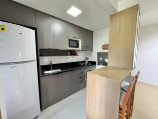 Vista da cozinha moderna com armários cinzas e bancadas escuras.