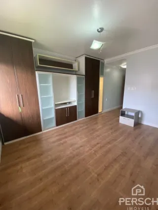 Sala de estar com piso de madeira e armários embutidos.