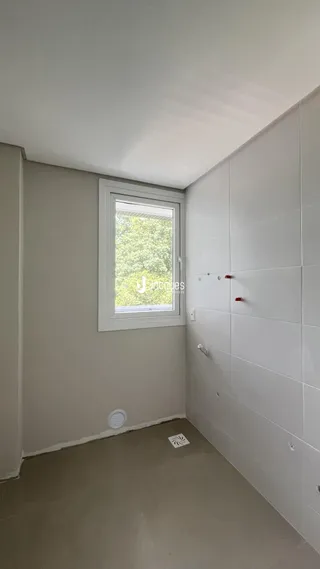 Corredor interno com parede branca e janela.
