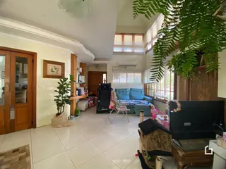 Sala de estar iluminada com piso claro e portas de madeira na residência.