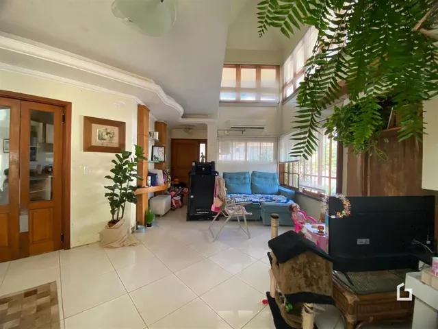 Sala de estar iluminada com piso claro e portas de madeira na residência.