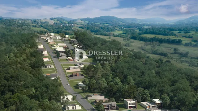 Vista aérea de uma área residencial com casas e vegetação ao redor.