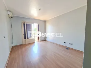 Sala de estar com piso de madeira clara e paredes brancas.