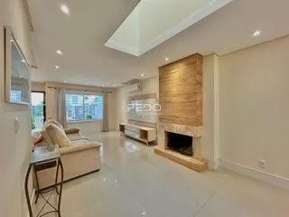 Sala de estar moderna com piso de cerâmica e lareira em um imóvel no Brasil.