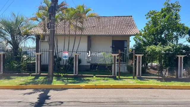 Fachada de uma residência em Lajeado, Brasil, com cerca e vegetação ao redor.