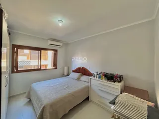 Quarto com cama e janela de madeira na residência.