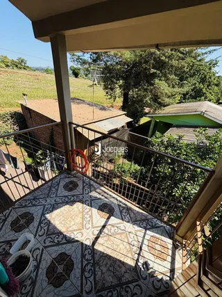 Vista da varanda com piso de cerâmica e paisagem verde.