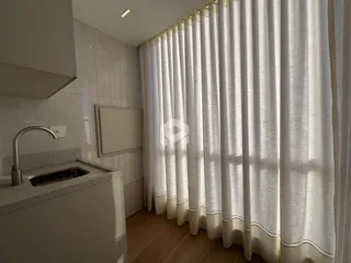 Foto de um banheiro com cortinas brancas.