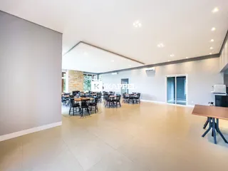 Ambiente amplo com mesas e cadeiras em um espaço de jantar.
