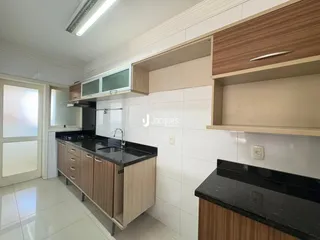Foto de uma cozinha com armários de madeira e revestimento branco.
