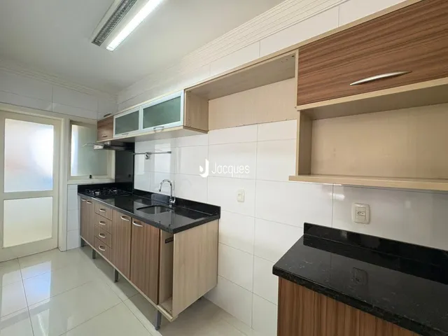 Foto de uma cozinha com armários de madeira e revestimento branco.