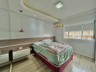 Quarto com cabeceira de madeira e janela.