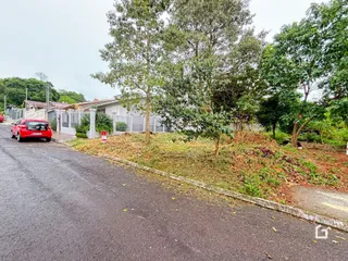Vista da fachada de uma residência em Lajeado, Brasil, com vegetação densa na frente.