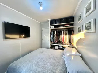 Quarto com cama e estante de roupas.