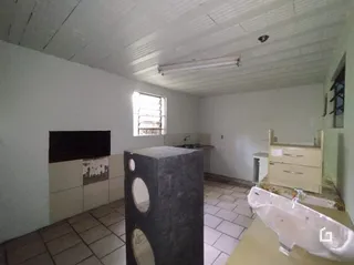 Interior de uma sala com piso de cerâmica e uma estrutura central de pedra.