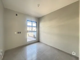 Vista interna de um ambiente com paredes cinzas e piso de cerâmica.