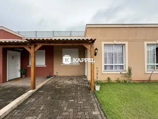 Fachada de uma residência em Lajeado, Brasil, mostrando a entrada coberta e a área gramada.