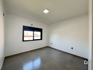 Ambiente interno de uma sala com piso de cerâmica e janela grande.