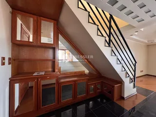 Interior com armários de madeira e escadaria em um imóvel.