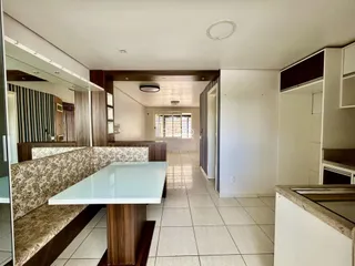 Uma sala de jantar com mesa e bancos em um ambiente interno.