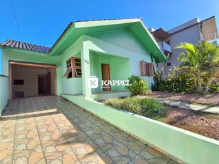 Fachada de uma residência verde com garagem e jardim em Lajeado, Brasil.