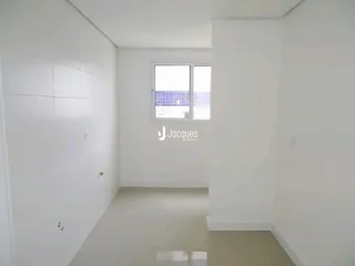 Foto interna de um ambiente claro com parede branca e janela.