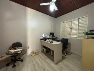 Quarto com piso de madeira e uma escrivaninha.