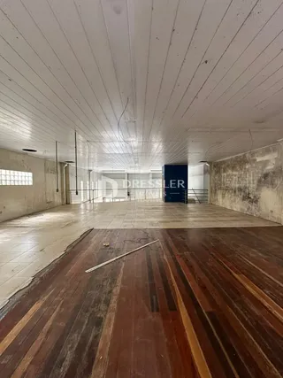 Vista interna de um corredor com piso de madeira no imóvel.