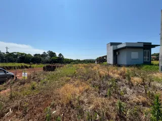 Foto da fachada de uma casa em uma área rural sob um céu azul claro.