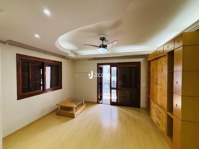 Sala de estar com piso de madeira e armários embutidos.