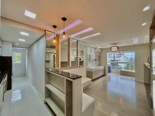 Ambiente interno de uma sala de estar moderna com piso de madeira clara e iluminação embutida.