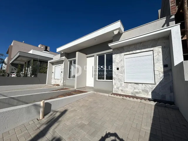 Fachada de uma residência moderna em Lajeado, Brasil, com área externa pavimentada.