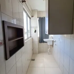 Corredor interno com paredes brancas e piso de cerâmica.