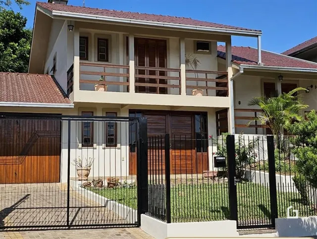 Fachada de uma casa de dois andares em Lajeado, Brasil, com cerca frontal.