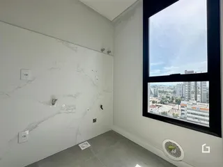 Interior de uma sala com paredes brancas e painéis de mármore branco.