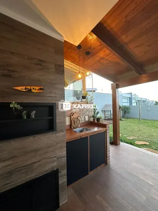 Esta é uma cozinha com bancada de madeira e piso de madeira em um ambiente aberto.
