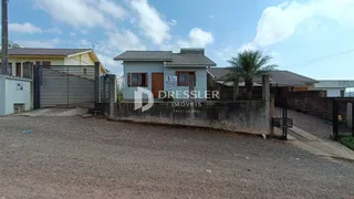 Fachada de uma residência com muro e portão de ferro.